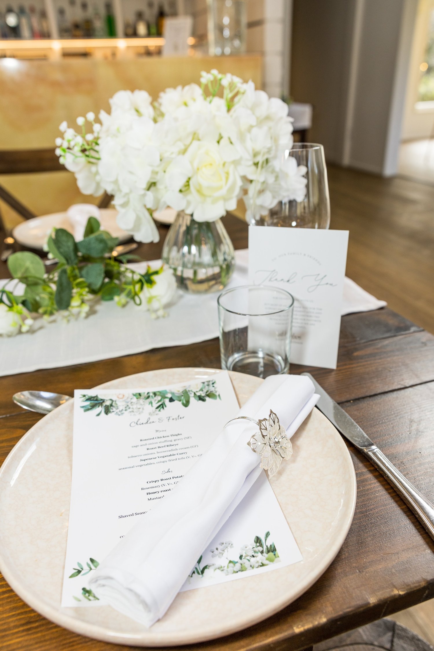 A place setting with white flowers and a printed menu