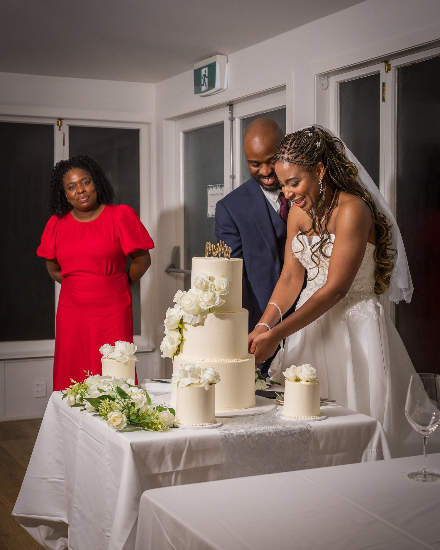 Chiedza and Foster cut their tiered white wedding cake