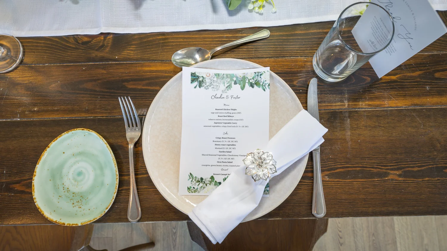 A place setting with a menu on a dark wooden table
