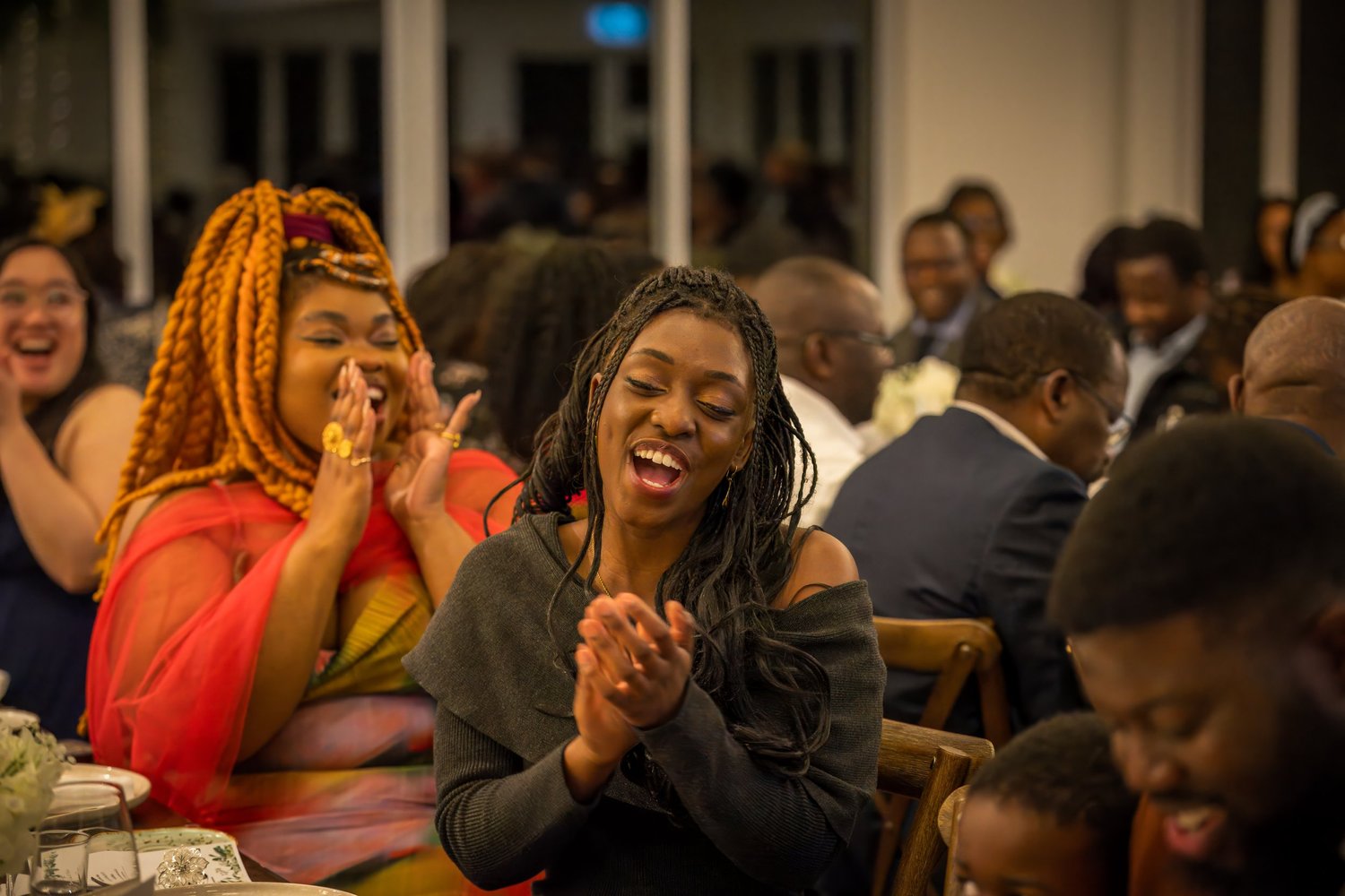 Guests laugh and clap during the reception