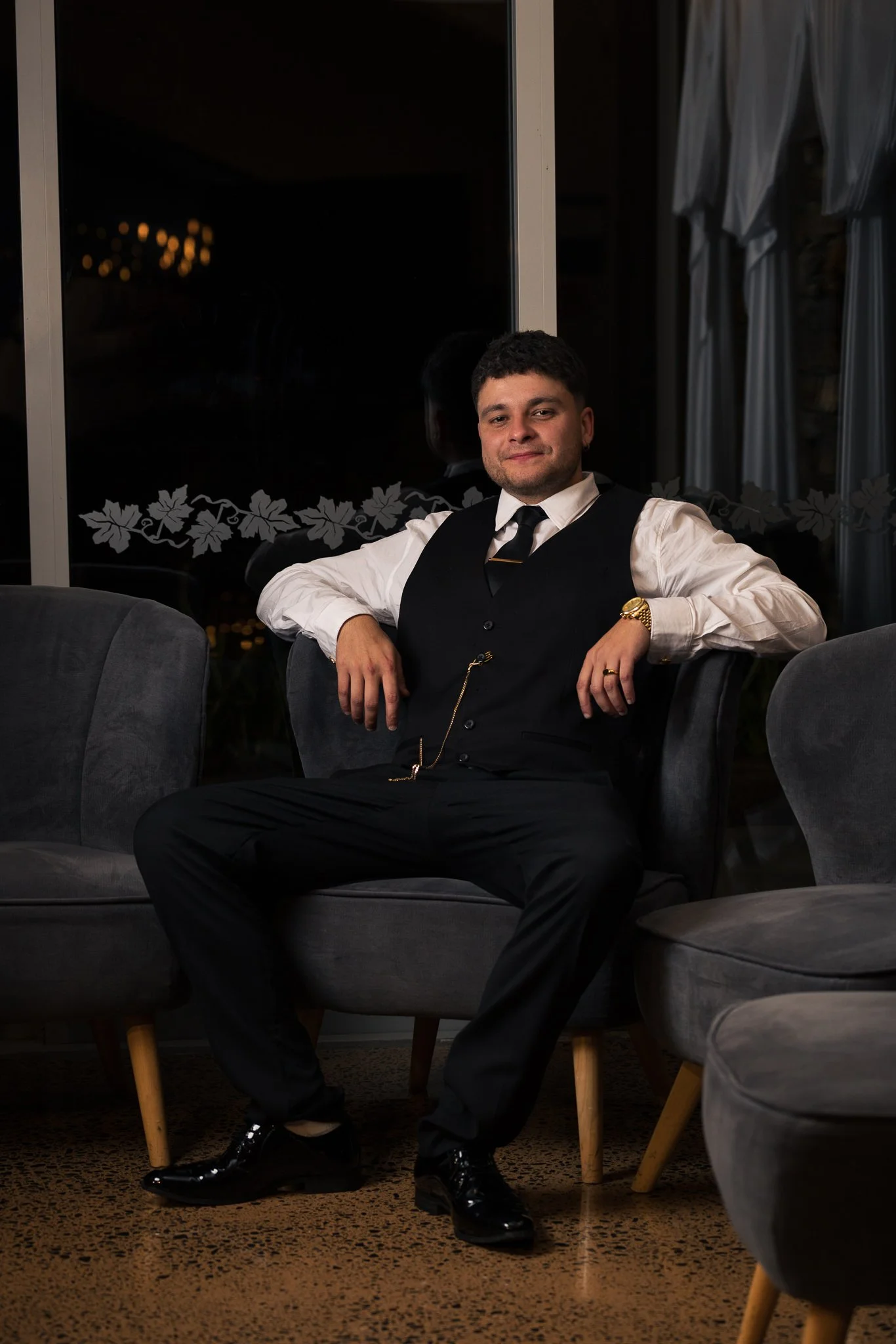 A groomsman seated in an armchair for a portrait