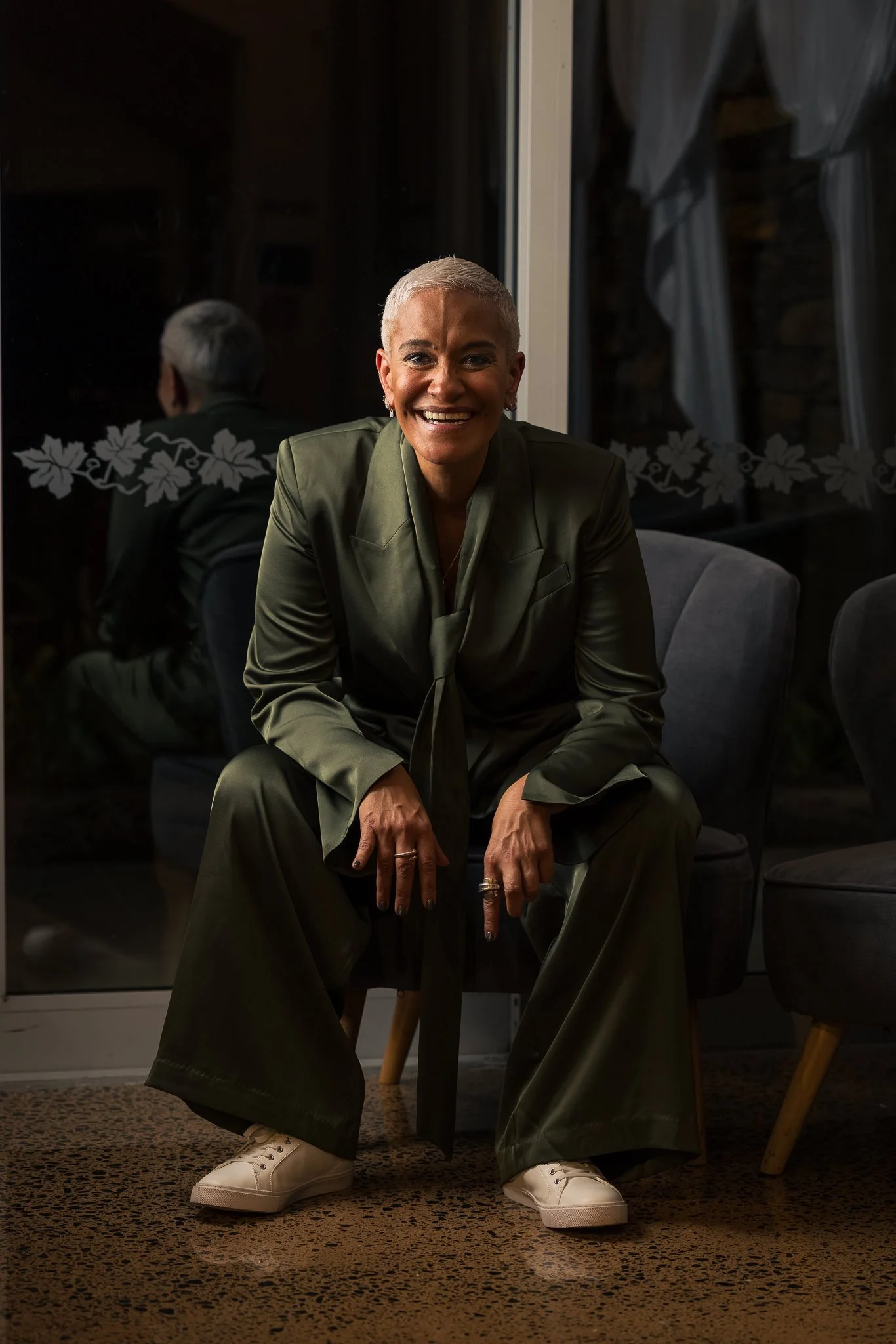 A guest in a green suit seated for a portrait