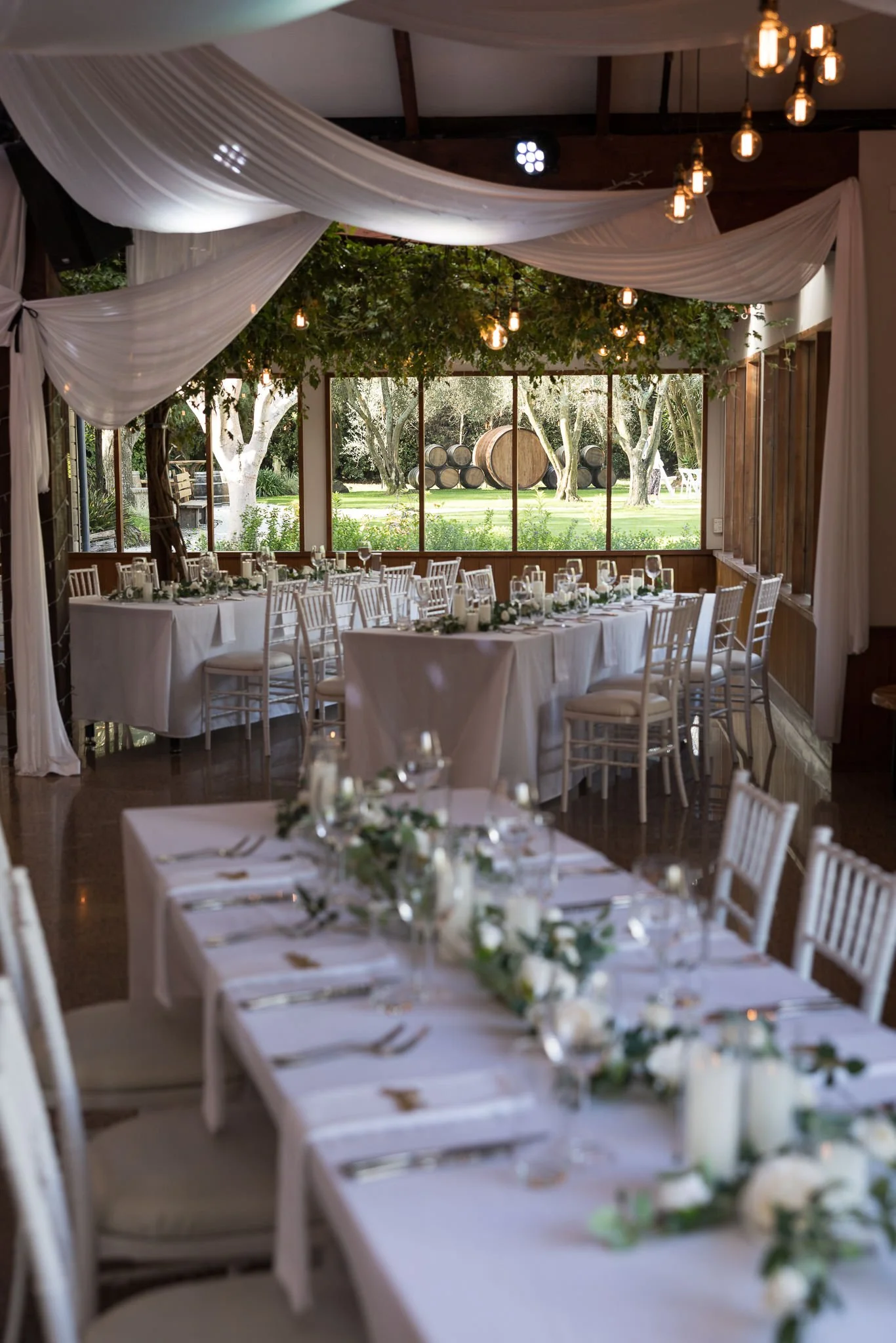 A long reception table with candles under a draped ceiling
