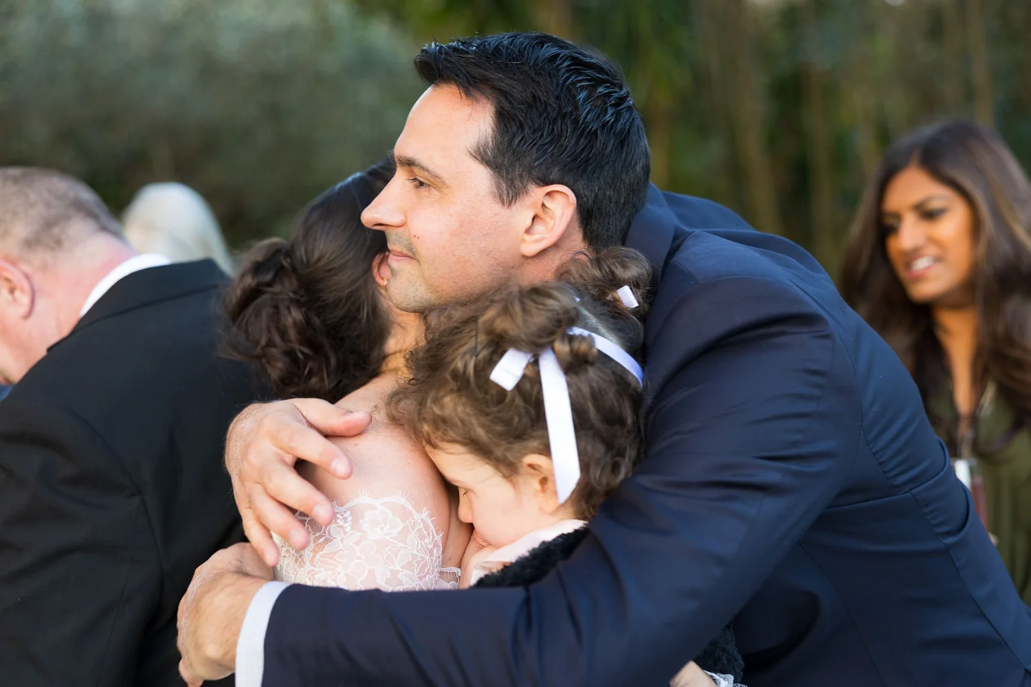 A guest hugs one of the couple's daughters after the ceremony