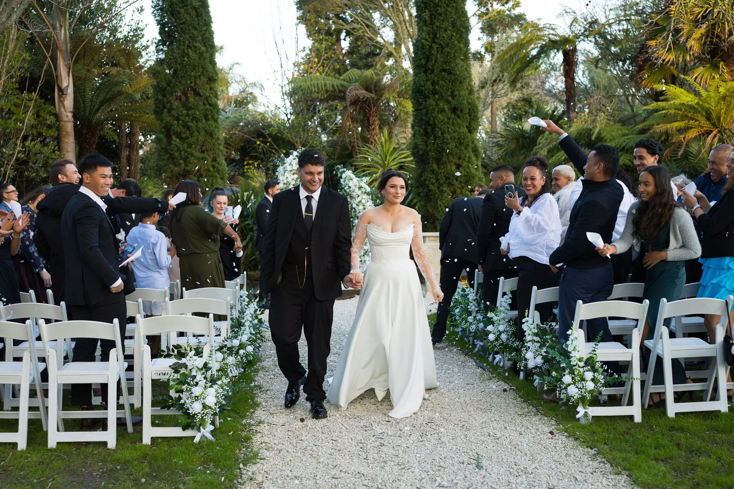 Paige and Connor walk back up the aisle past their guests