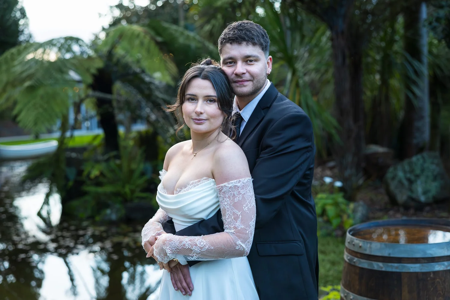 Paige and Connor by the pond with a wine barrel beside them