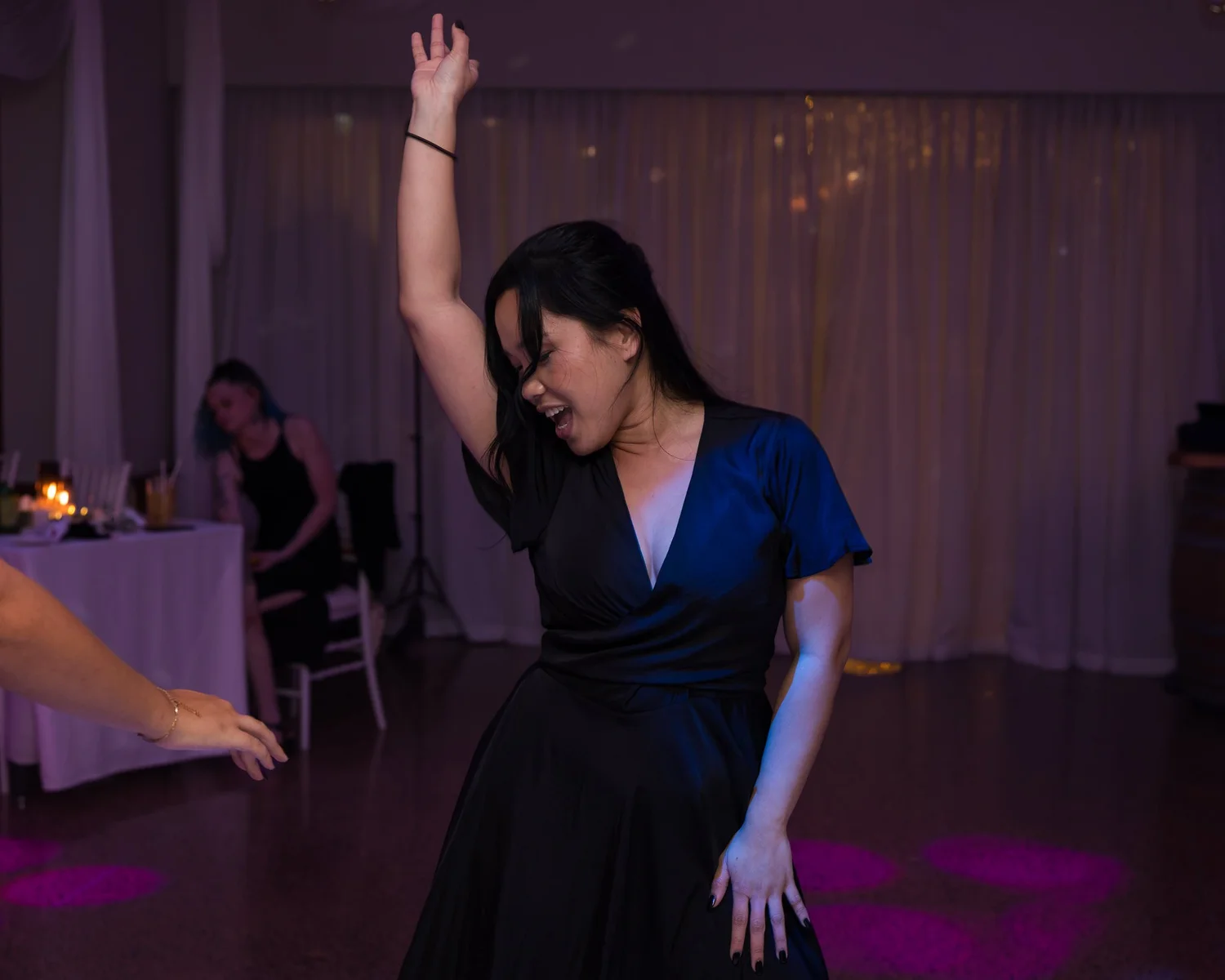A guest dances with her arm in the air
