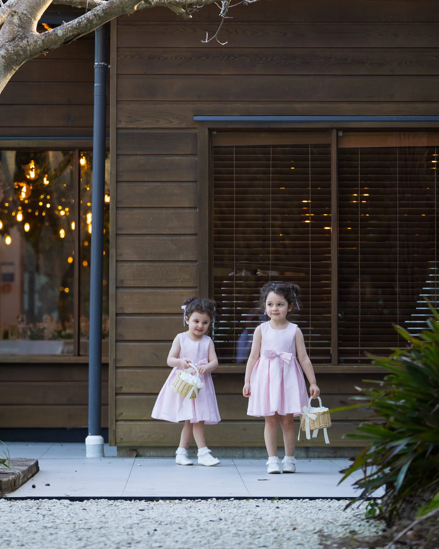 Paige and Connor's two daughters in pink dresses holding flower baskets