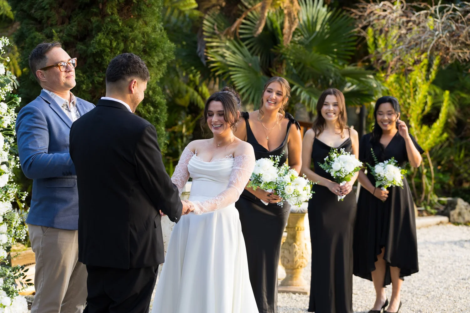 Paige with her bridesmaids in black dresses during the ceremony