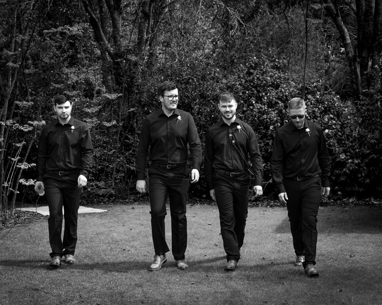 Black and white photo of Connor and his groomsmen walking