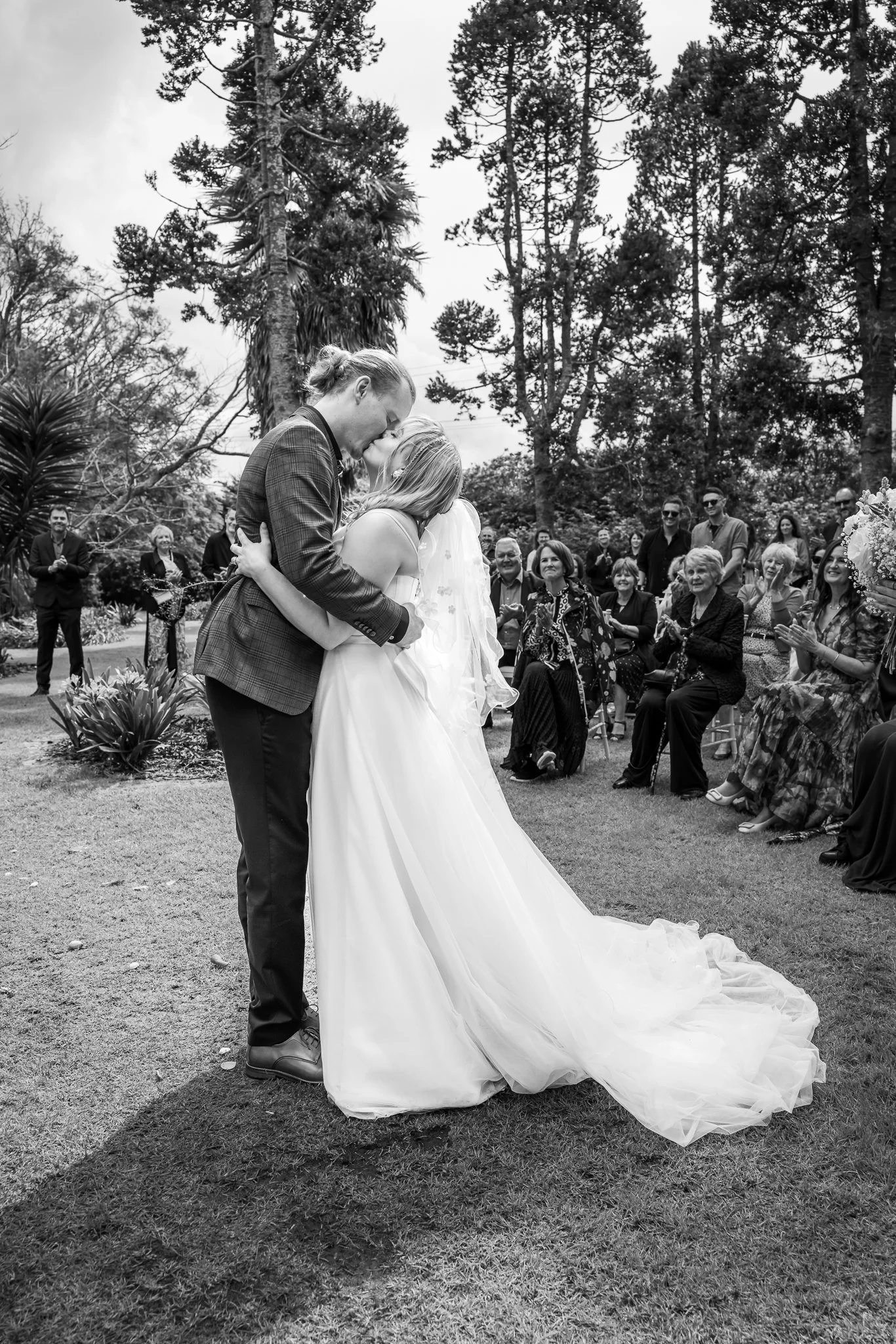 Black and white photo of Shannon and Connor kissing in the aisle