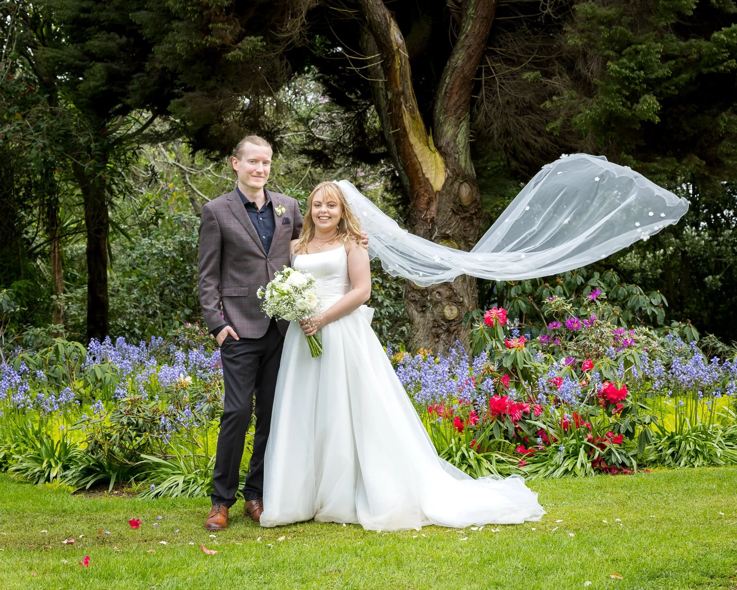Shannon's veil catches the wind as she stands with Connor in the garden