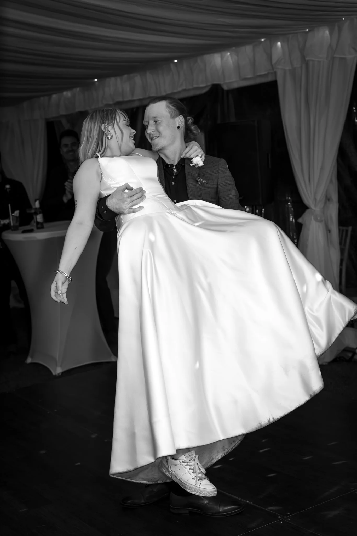 Black and white photo of Connor lifting Shannon during their first dance