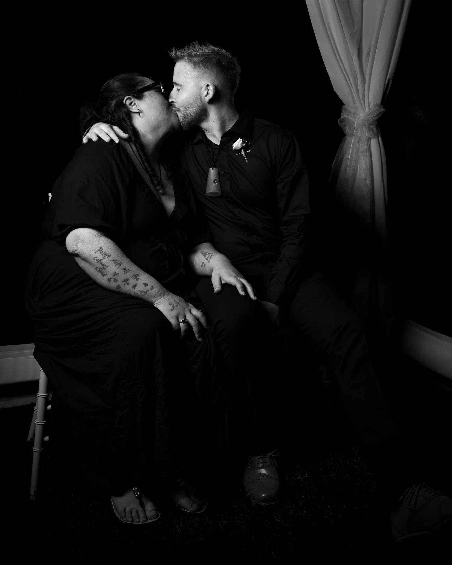 Black and white photo of two guests kissing