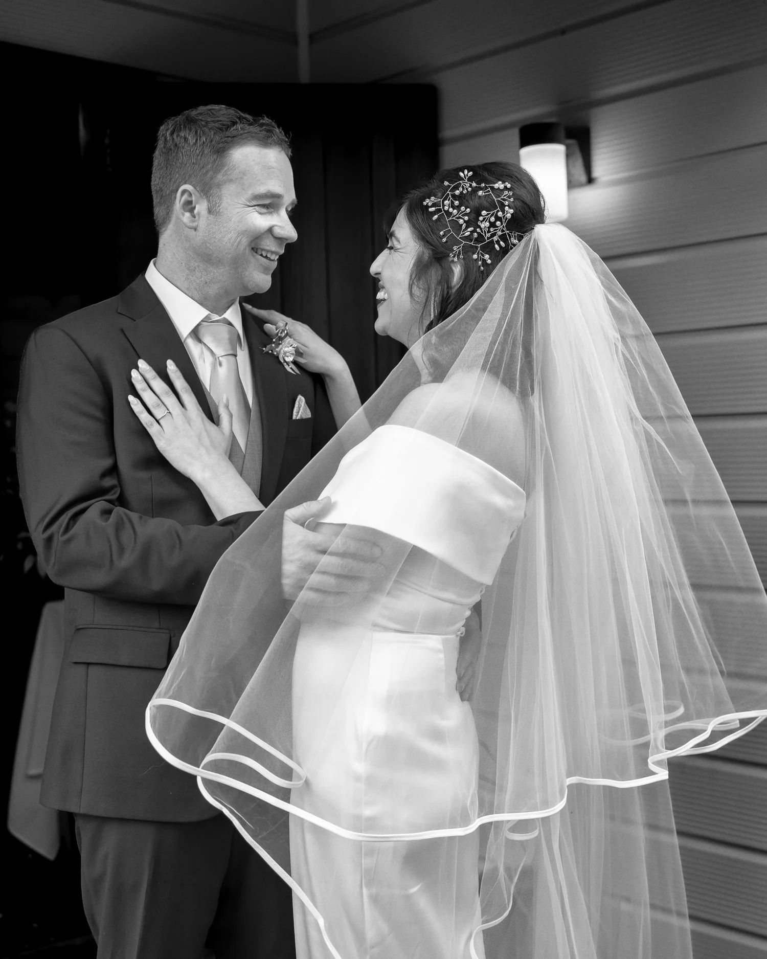 Black and white photo of Feby and Steven facing each other in a doorway