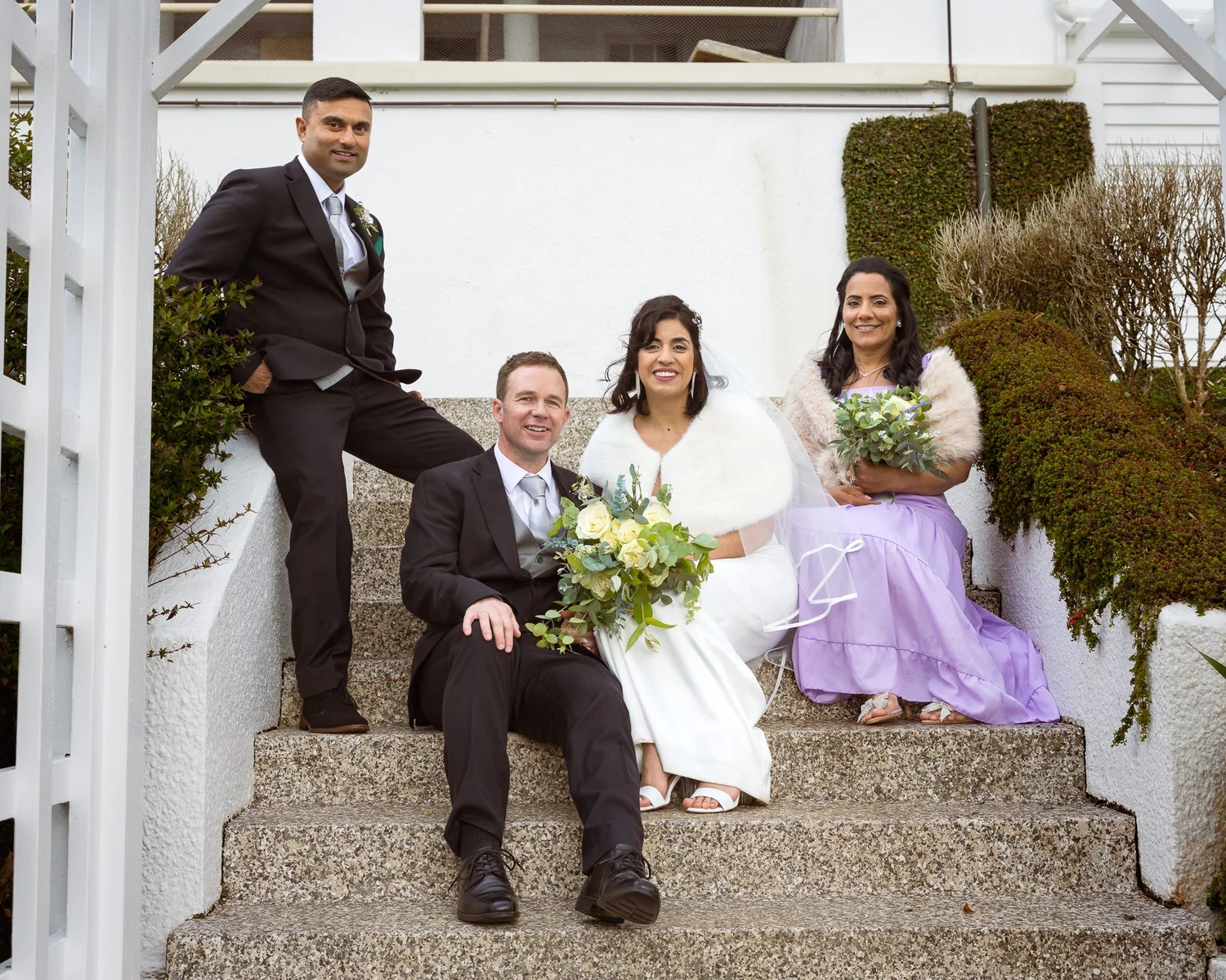 Feby and Steven with their bridal party on garden steps