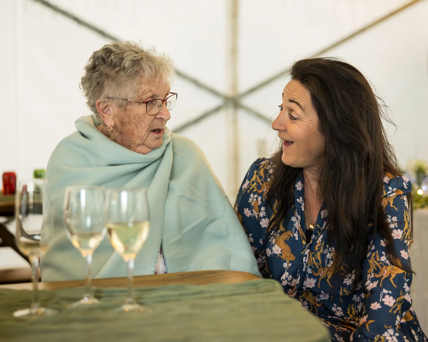 Two guests chat and laugh at the reception