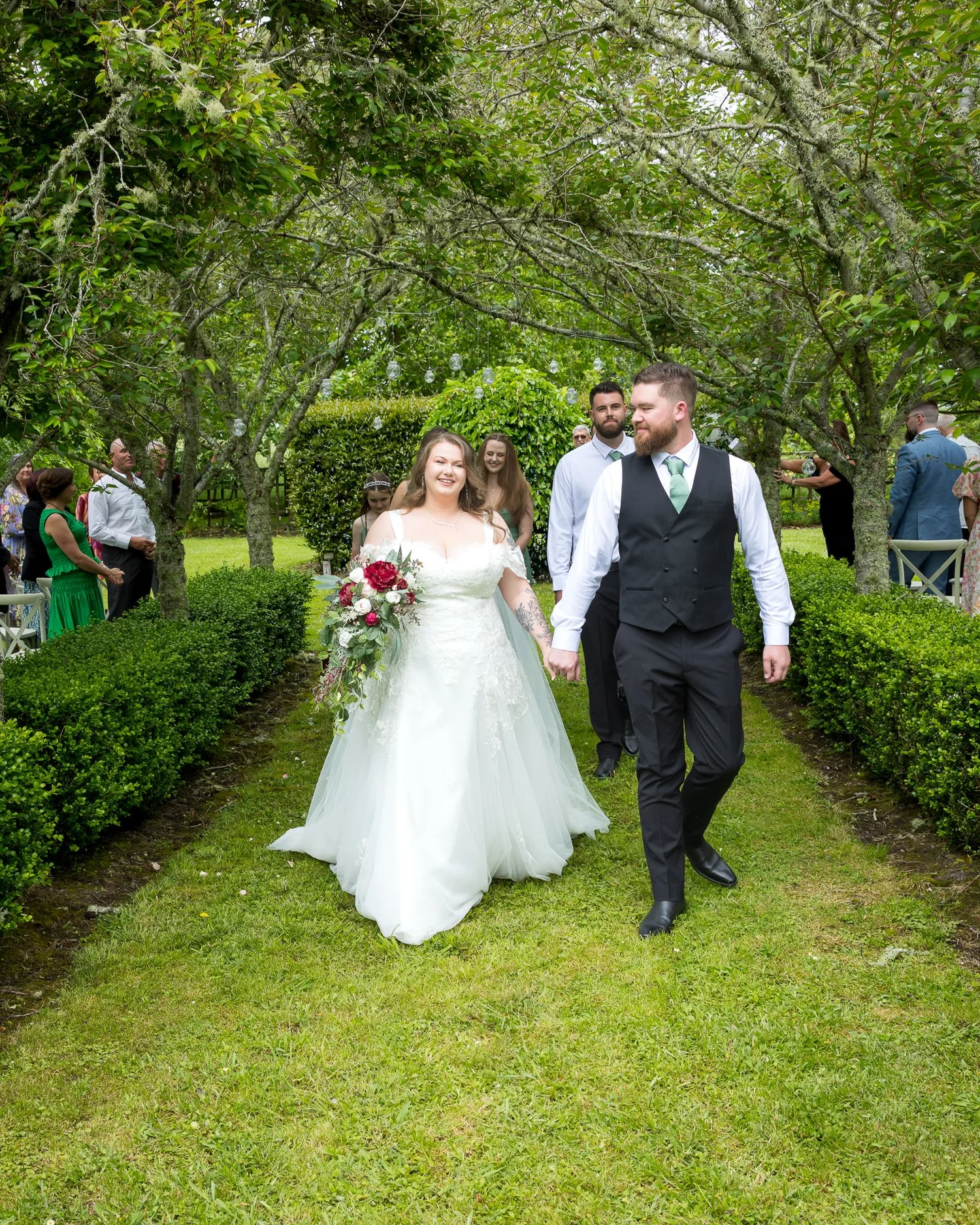 Janine and Kyle walk back up the grassy aisle