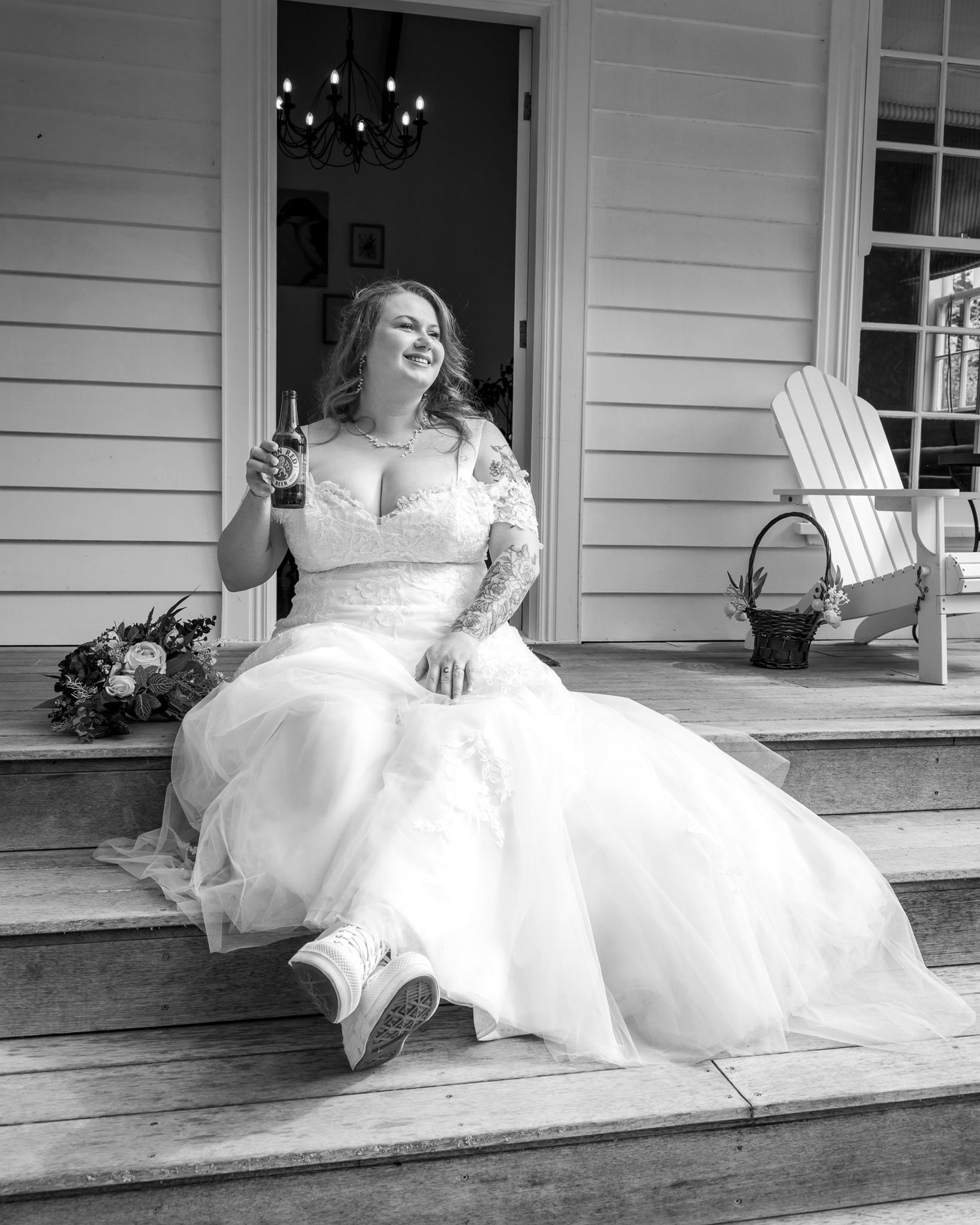 Black and white photo of Janine sitting on the veranda steps
