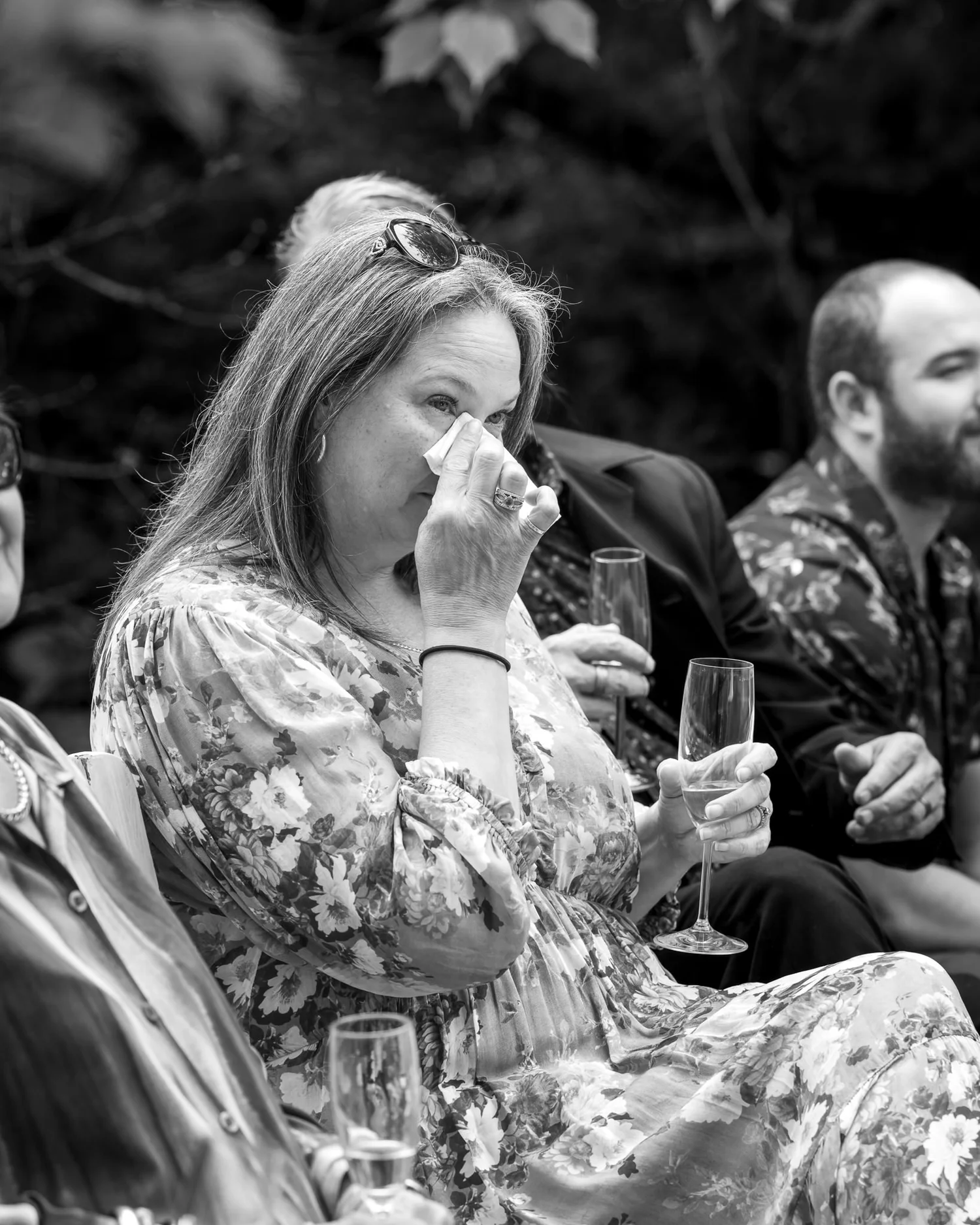 Black and white photo of a guest wiping away tears during the ceremony