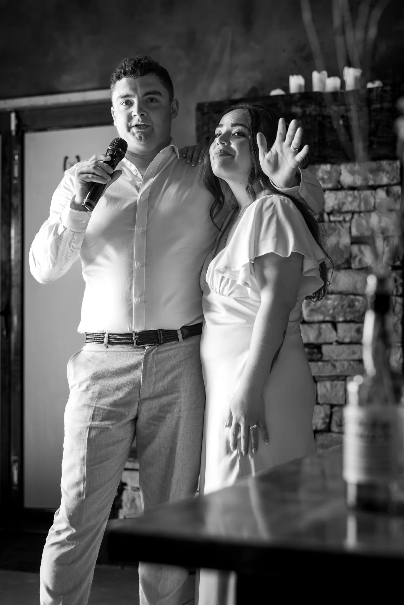 Black and white photo of Nick speaking into a microphone beside Cerise
