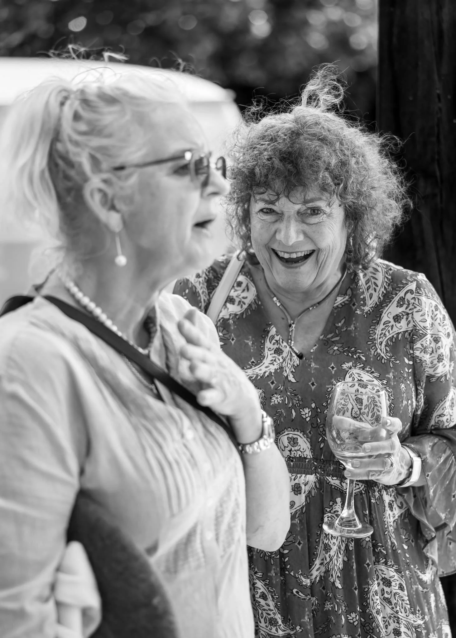 Black and white photo of two guests sharing a laugh