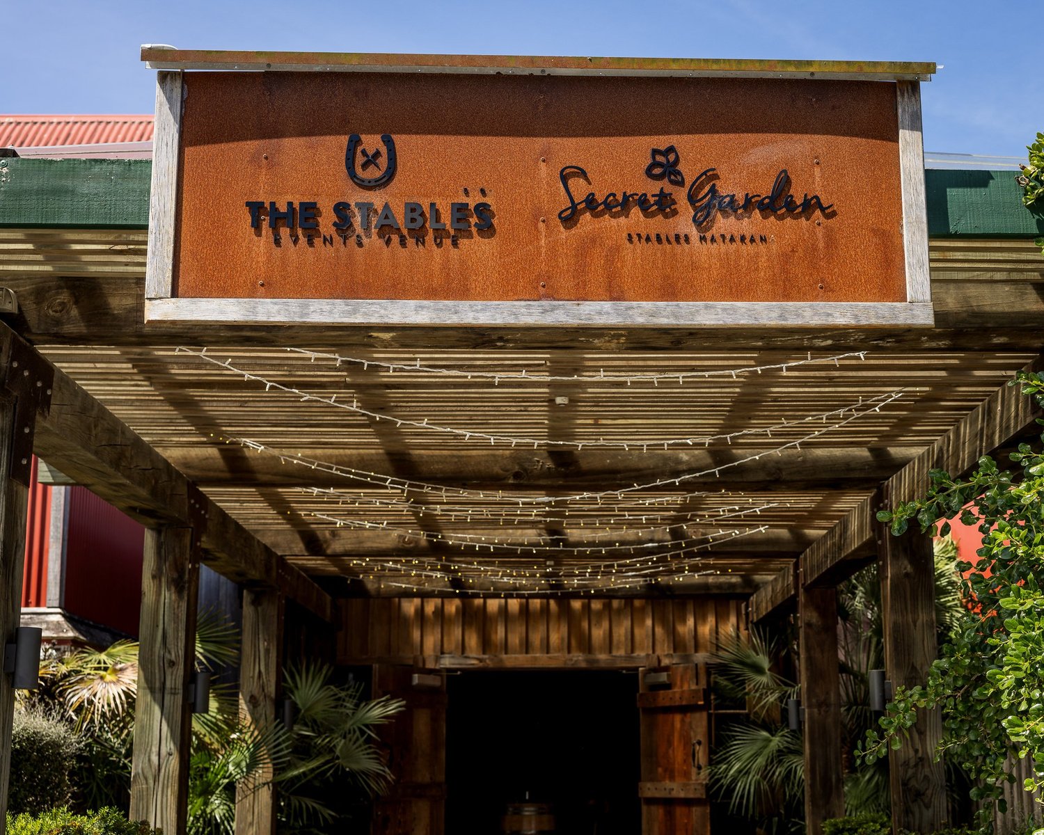 The entrance sign at The Stables and Secret Garden in Matakana