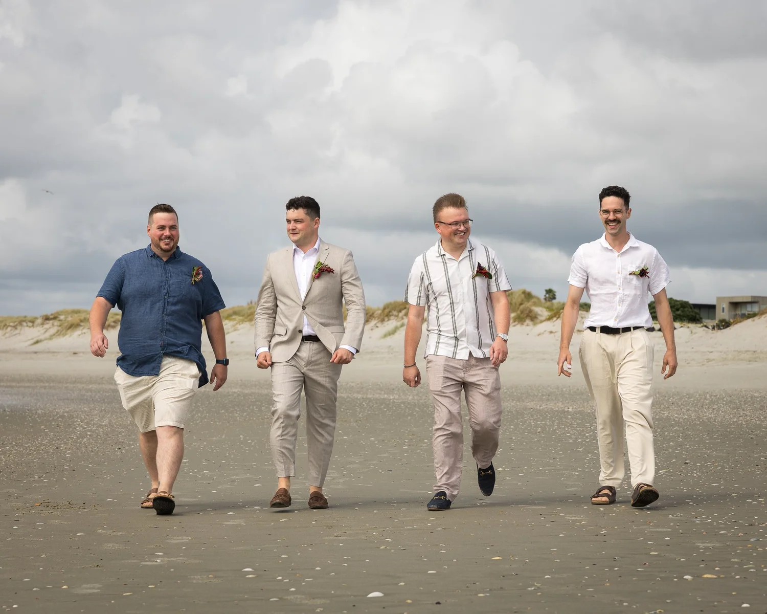 Nick and his groomsmen walk along the beach