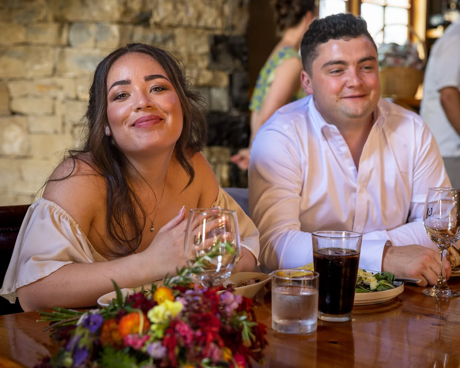 Cerise and Nick smile at their reception table