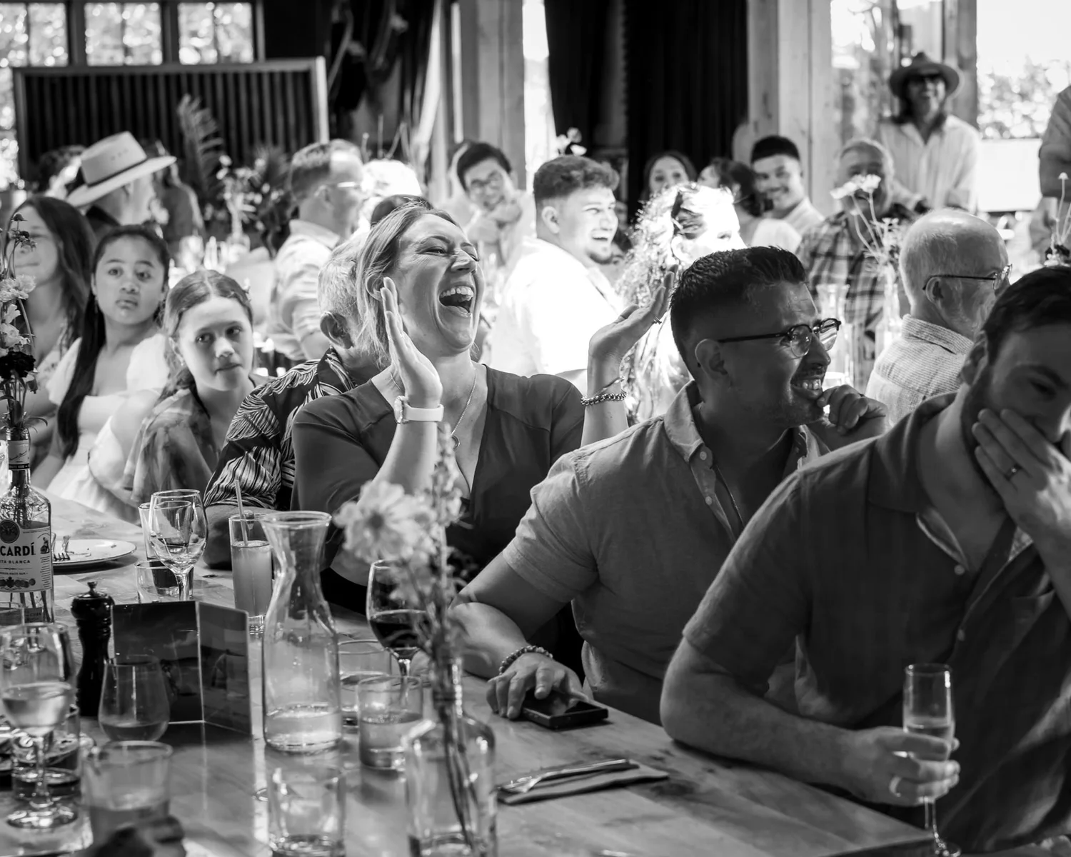 Black and white photo of guests laughing during the speeches