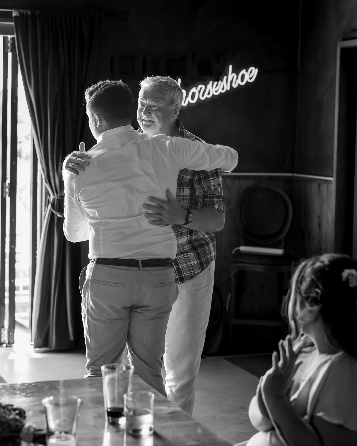 Black and white photo of Nick hugging a guest