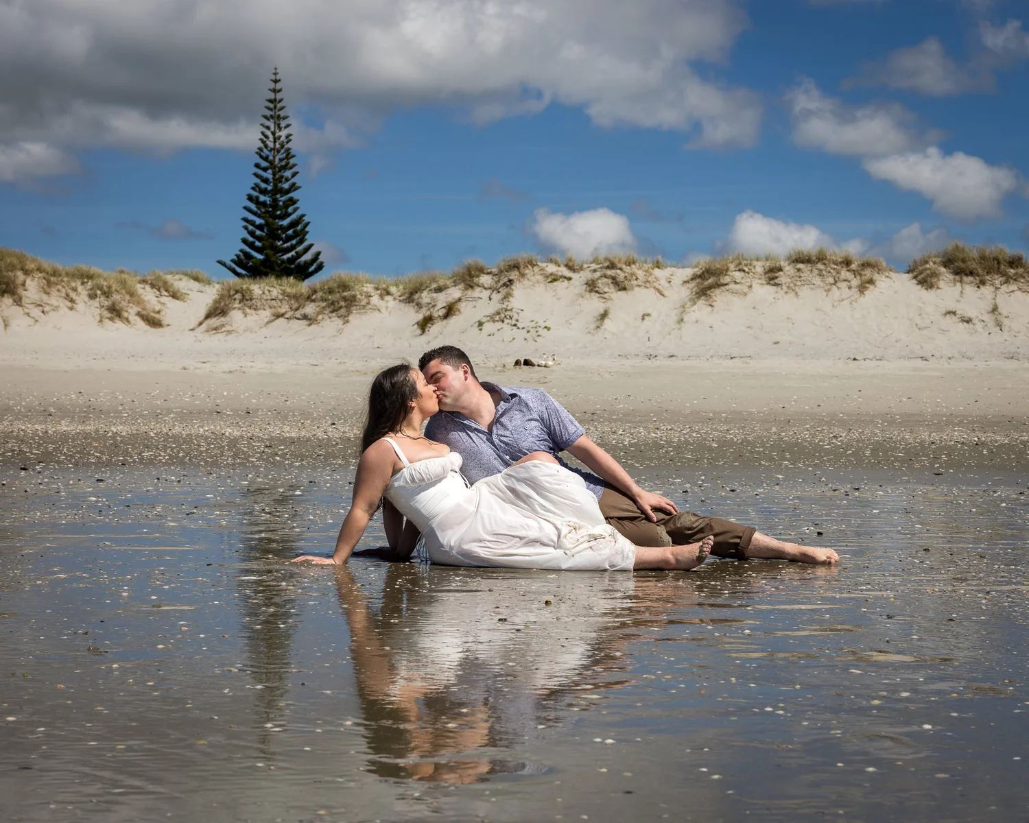 Cerise and Nick lie in the shallow water at Omaha Beach during their practice shoot