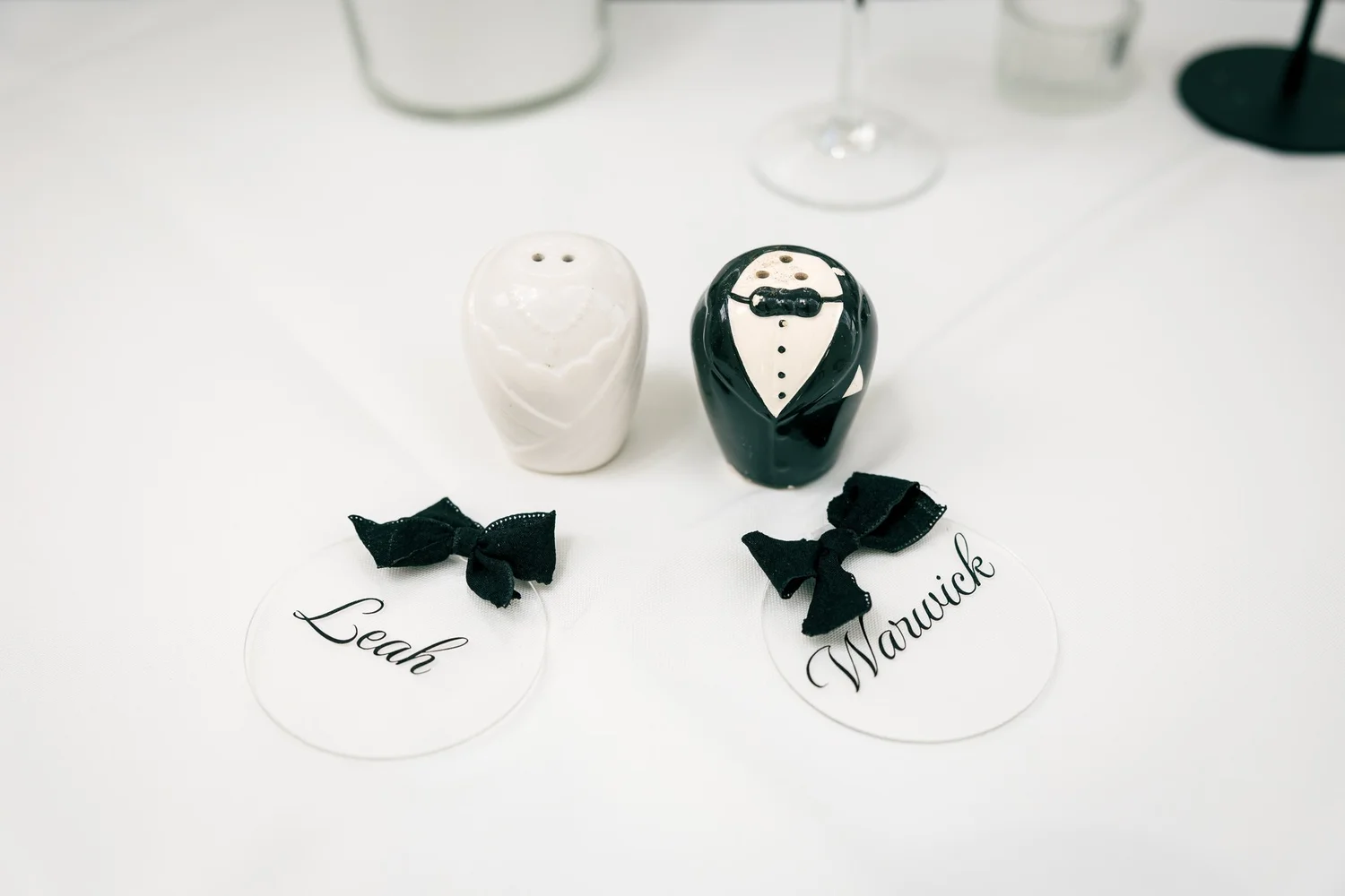 Leah and Warwick's name cards beside bride and groom salt and pepper shakers