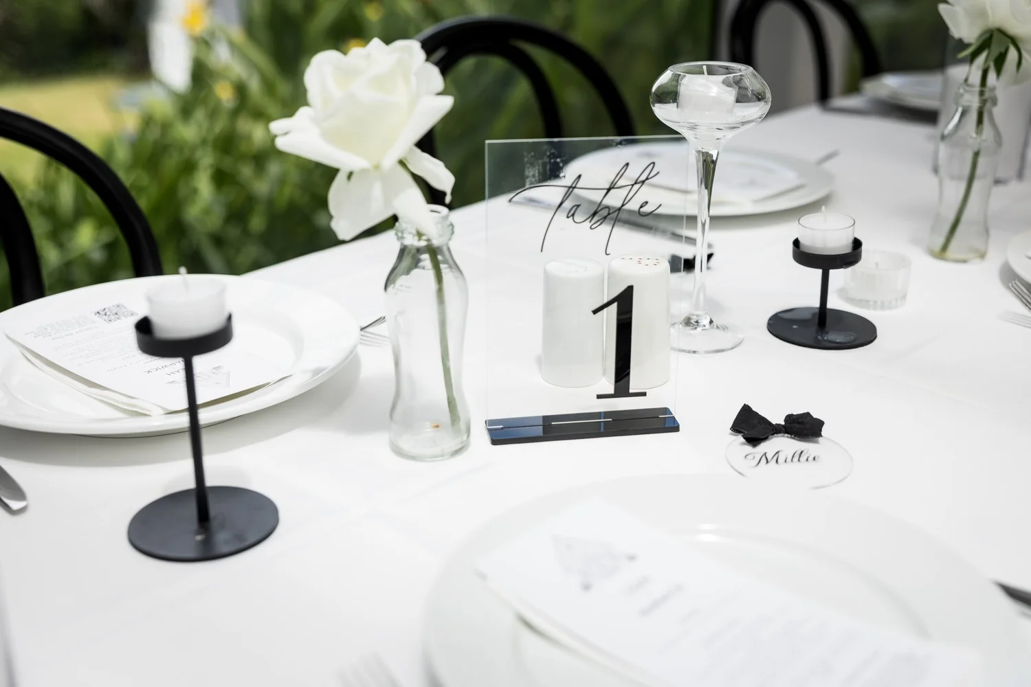 A reception table set with white roses and a table number