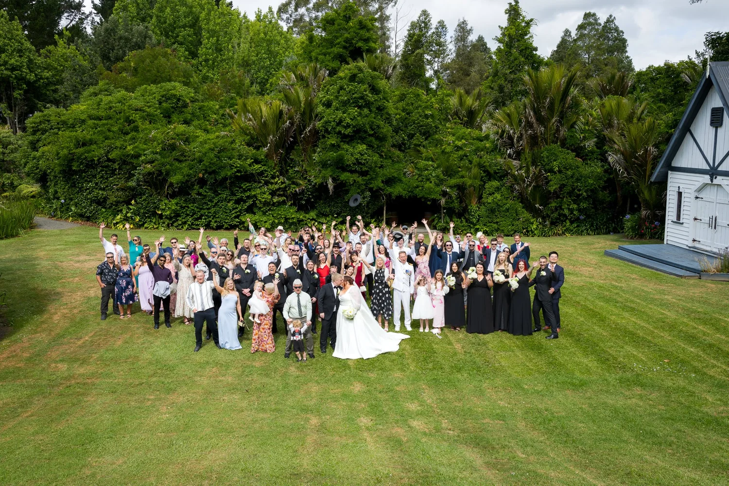 The full wedding party and guests gathered on the lawn
