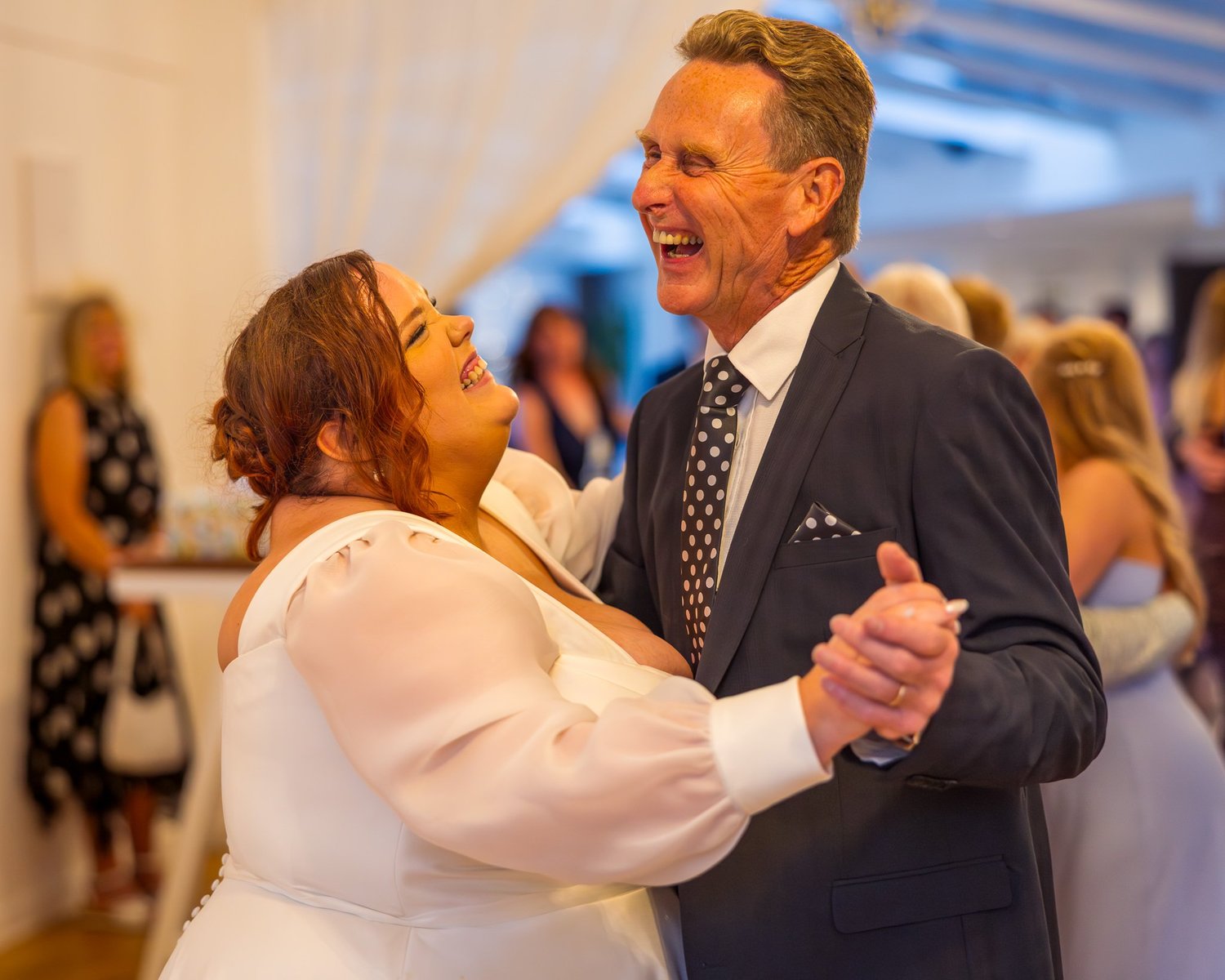 Leah laughs while dancing with a guest
