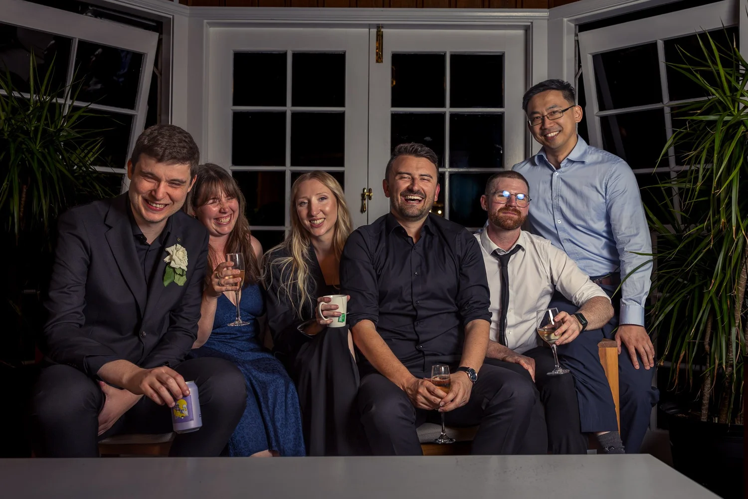A group of guests pose together on a sofa