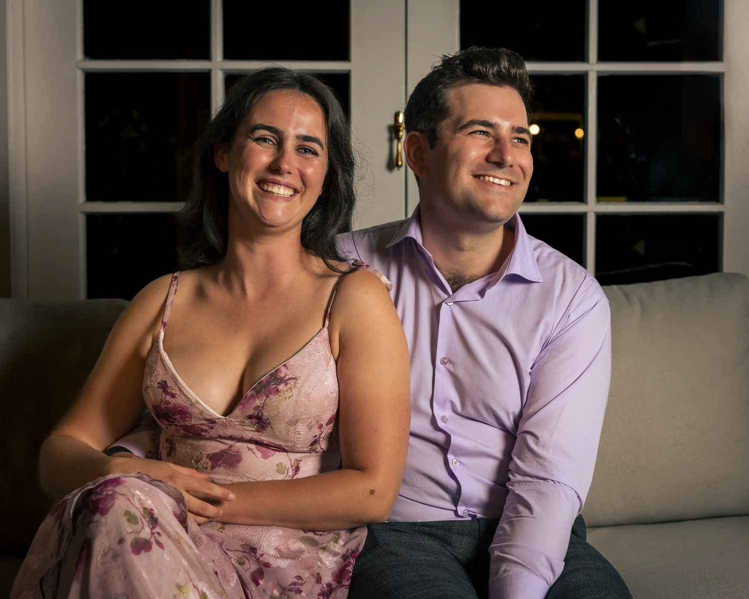 Two guests pose on a sofa at the reception
