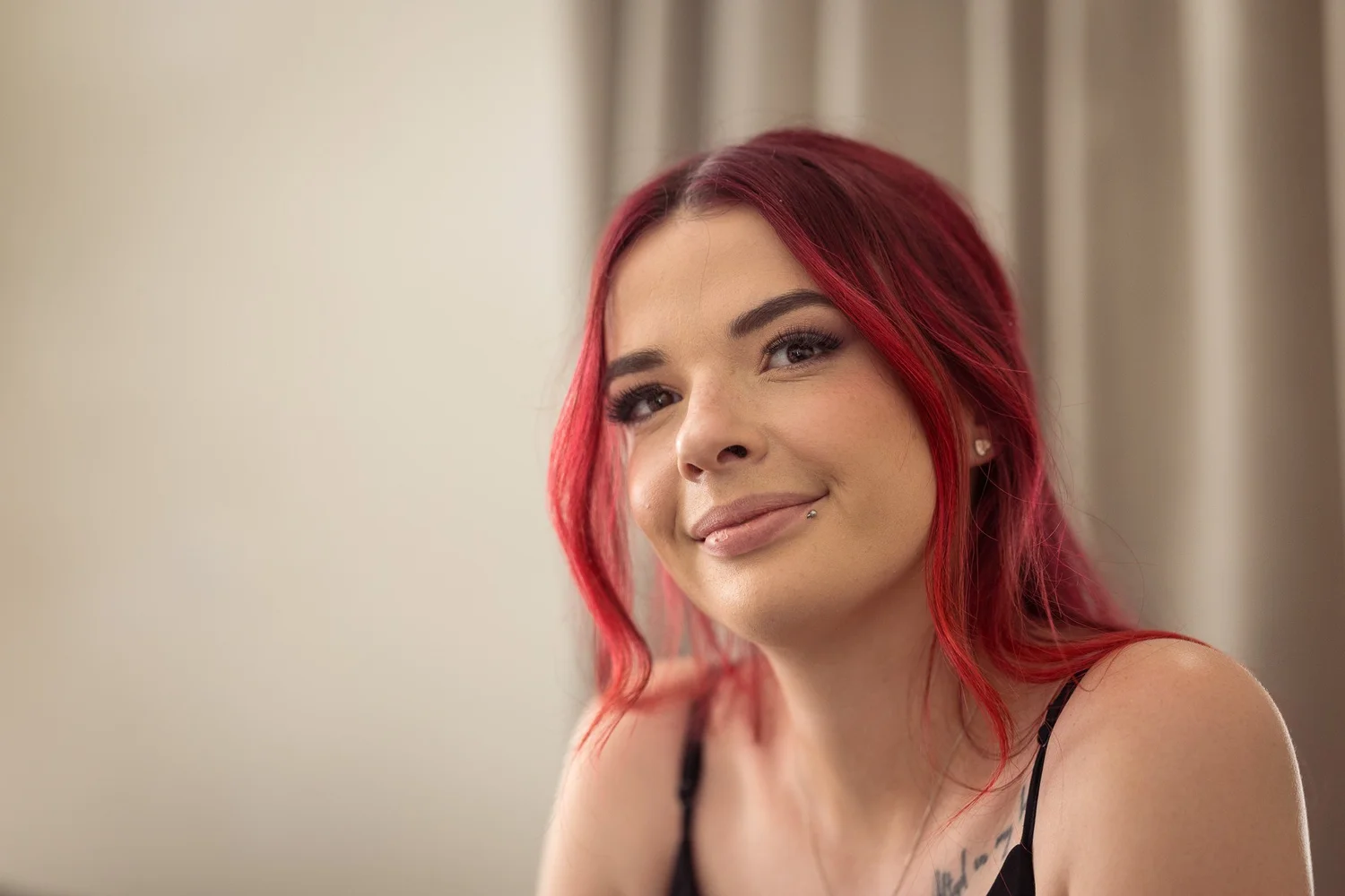A bridesmaid with red hair smiles during preparations