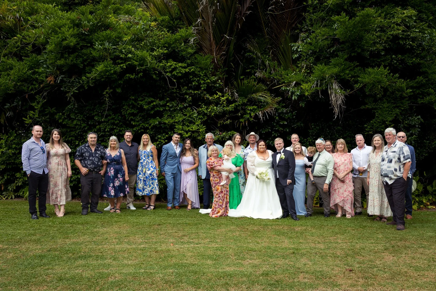 Leah and Warwick with a large group of guests on the lawn