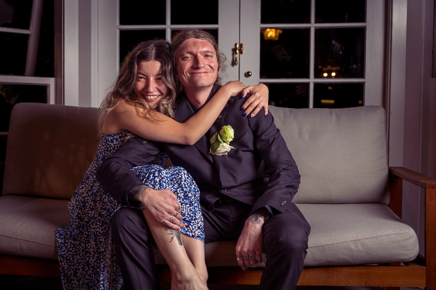 A couple of guests pose playfully on a sofa