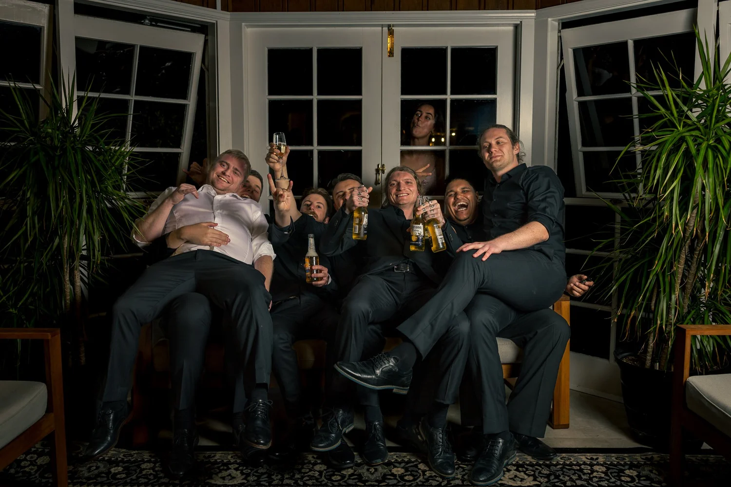 A group of guests crowded onto a sofa having fun