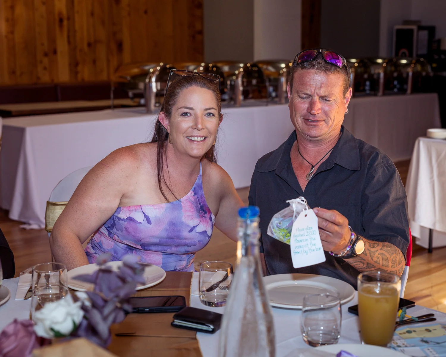 Two guests smile at their reception table