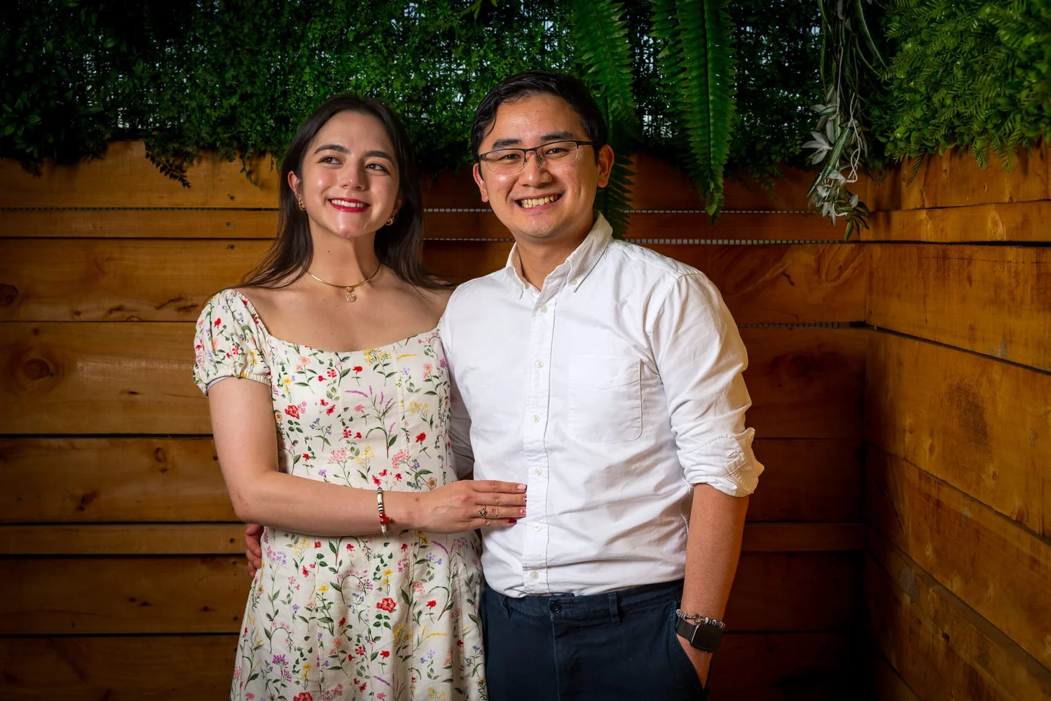 Two guests pose against the timber wall