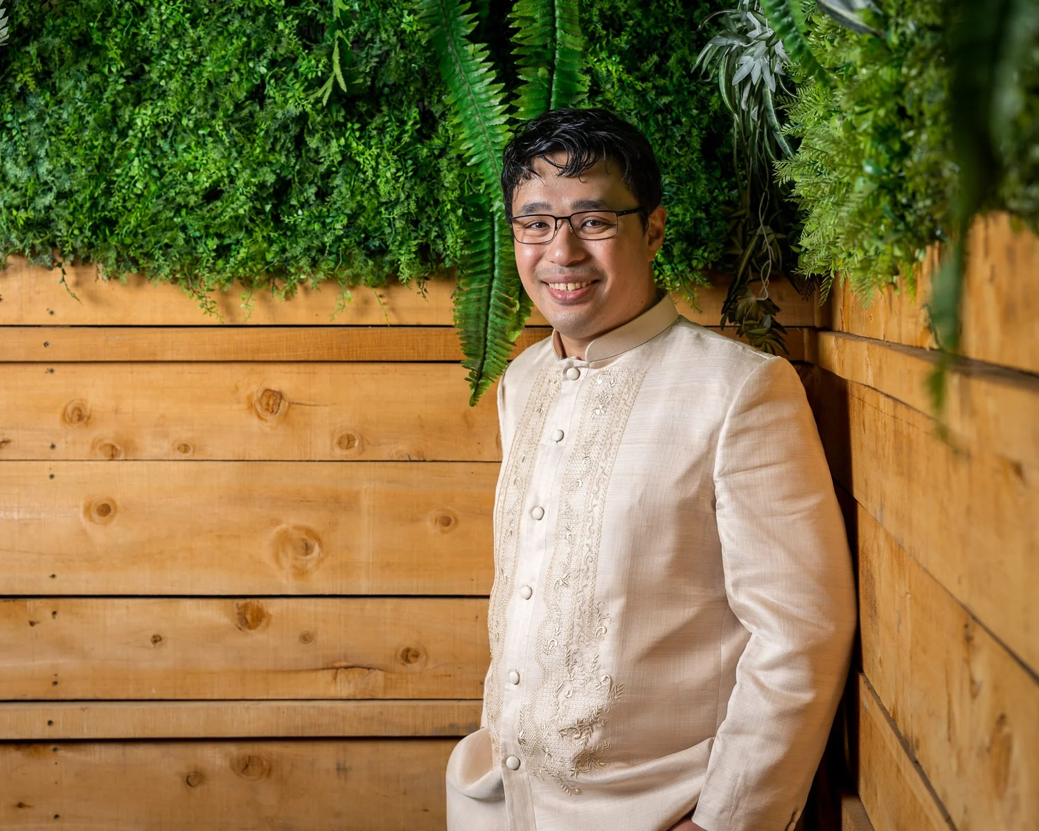 Justin in his barong shirt against the timber wall