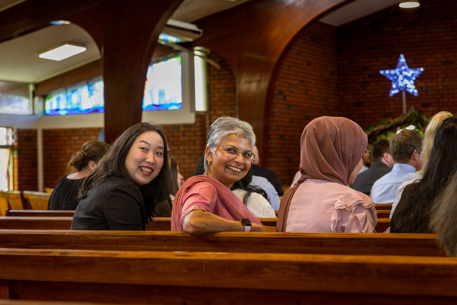 Guests smile from the pews before the ceremony