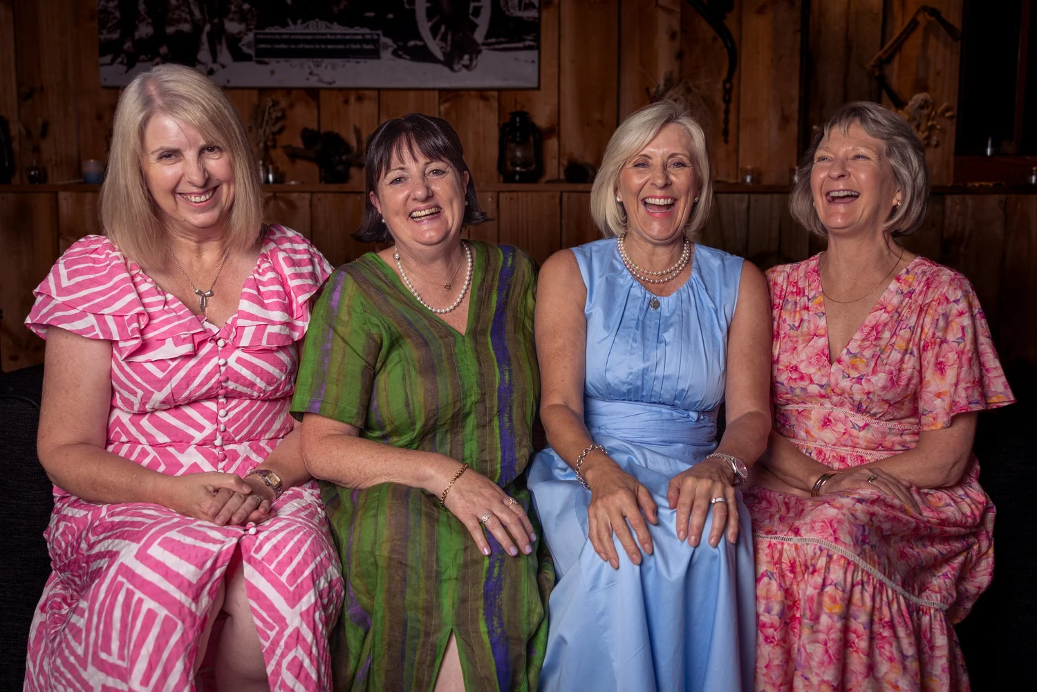Four guests in colourful dresses pose together