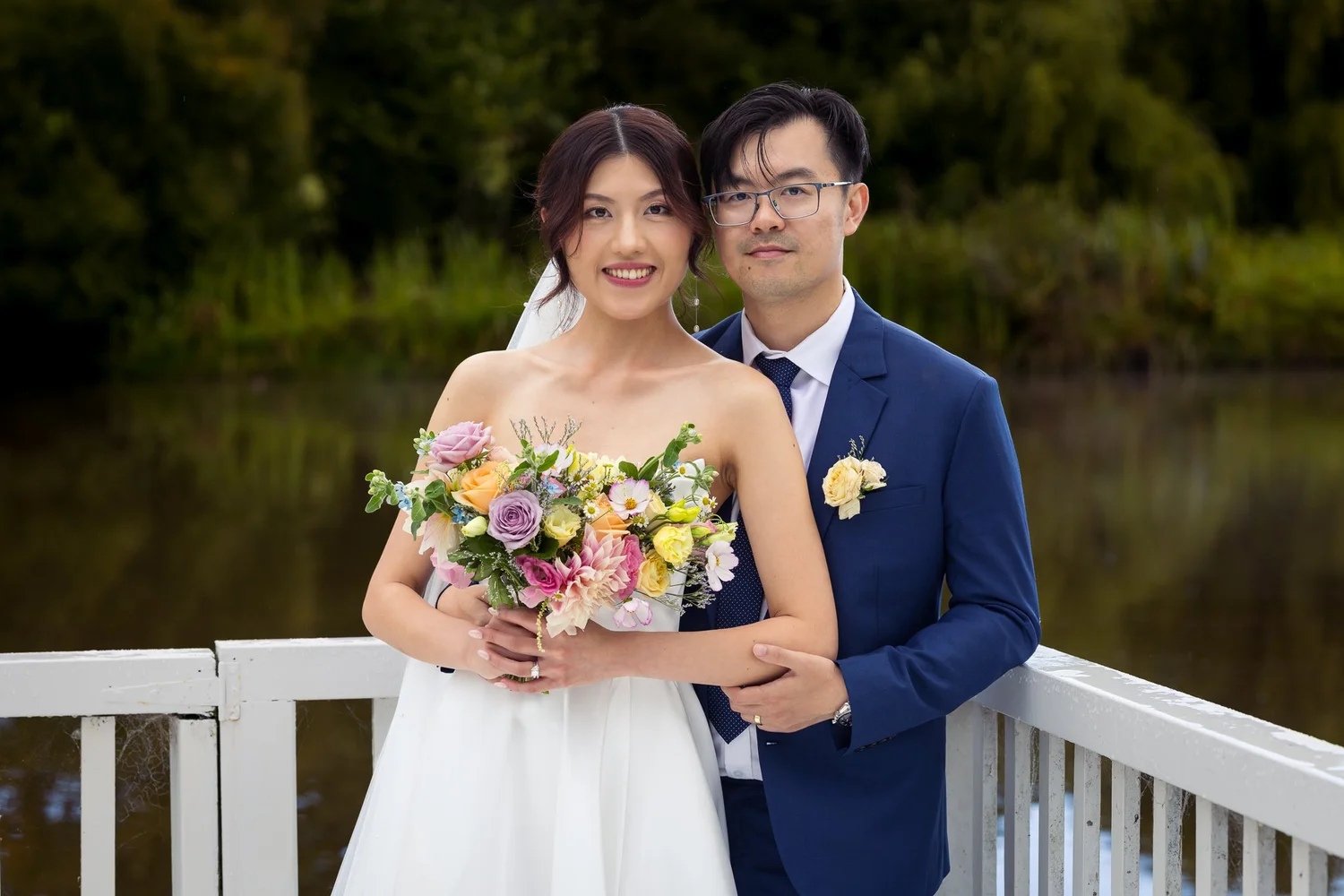 Cherry holds her bouquet beside Chi by the lake