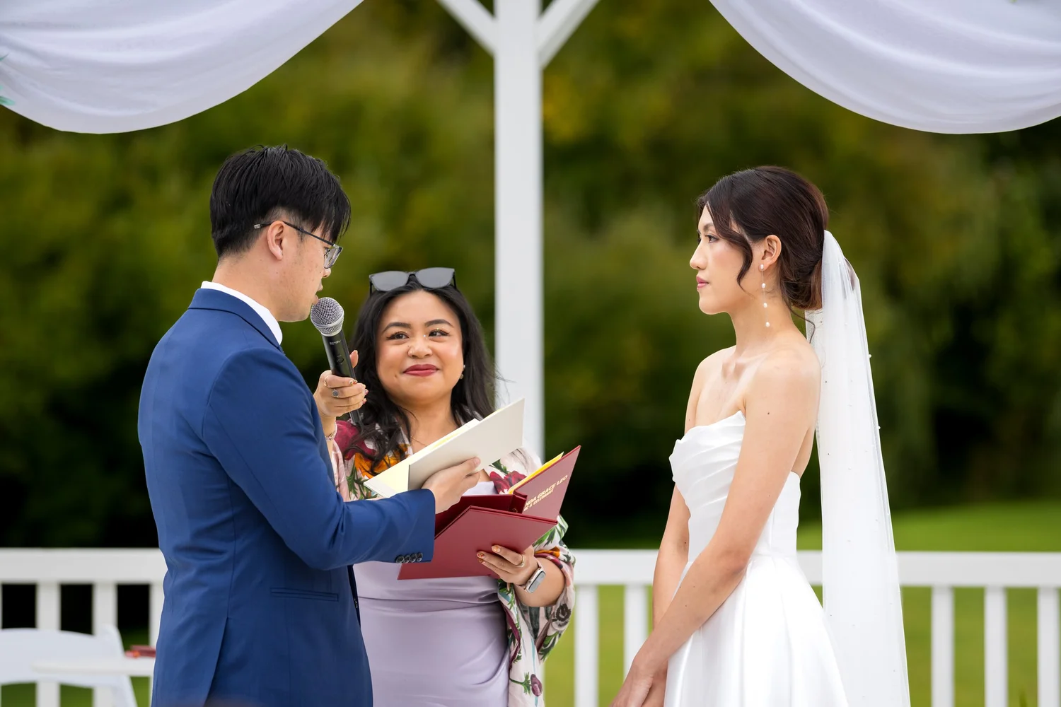 Chi reads his vows to Cherry beside the celebrant