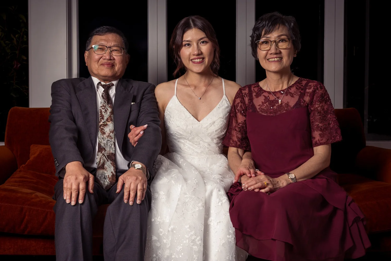 Cherry poses with family on a red velvet sofa